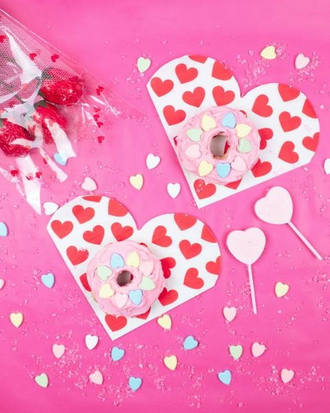 donuts on white and red heart shaped cards, flowers, and sweets
