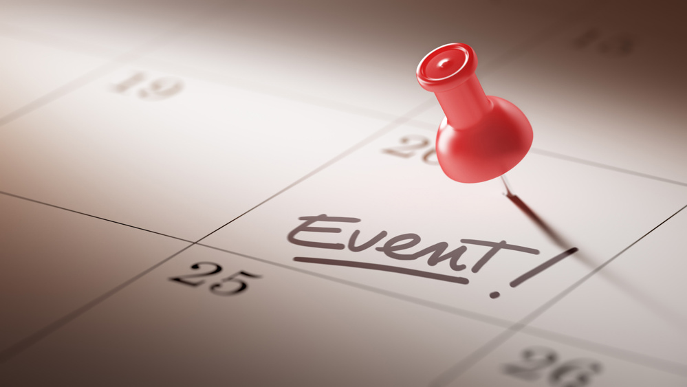 Concept image of a Calendar with a red push pin. Closeup shot of a thumbtack attached. The words Event written on a white notebook to remind you of an important appointment