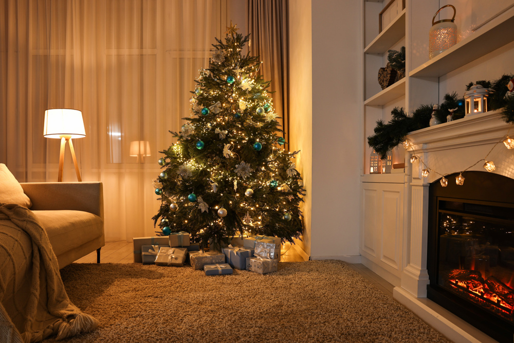 Christmas tree and decorated fireplace in room. Festive interior