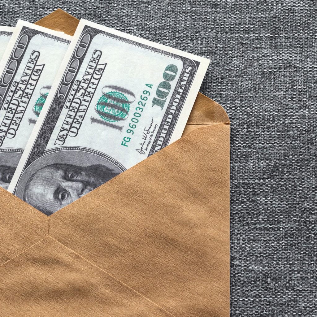 two one-hundred-dollar bills inside a brown envelope