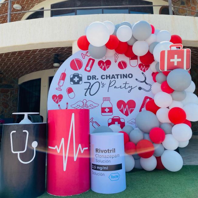 a party set up with red, white, and gray balloons and three huge medical-themed