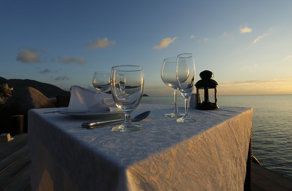 A dinner table by the beach at sunset