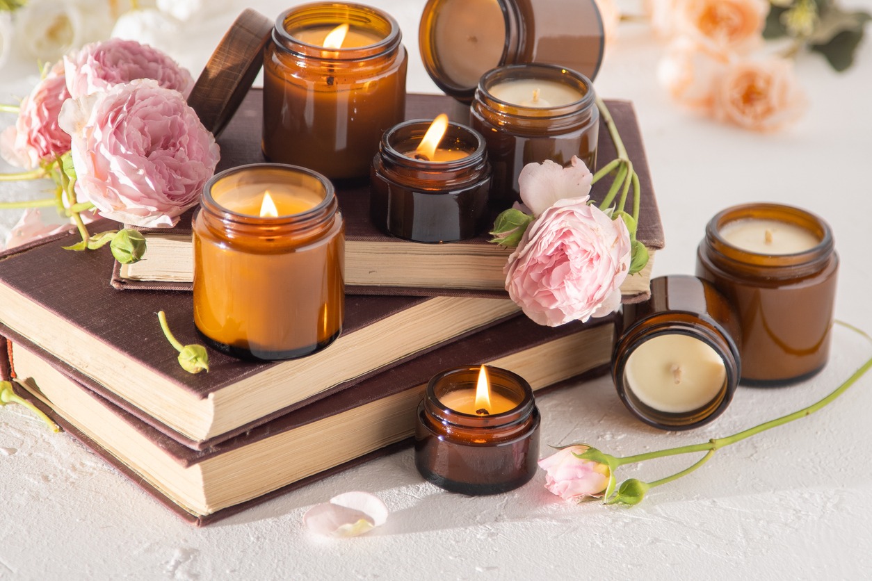 A set of different aroma candles in brown glass jars. Scented handmade candle. Soy candles are burning in a jar. Aromatherapy and relax in spa and home. Fire in brown jar