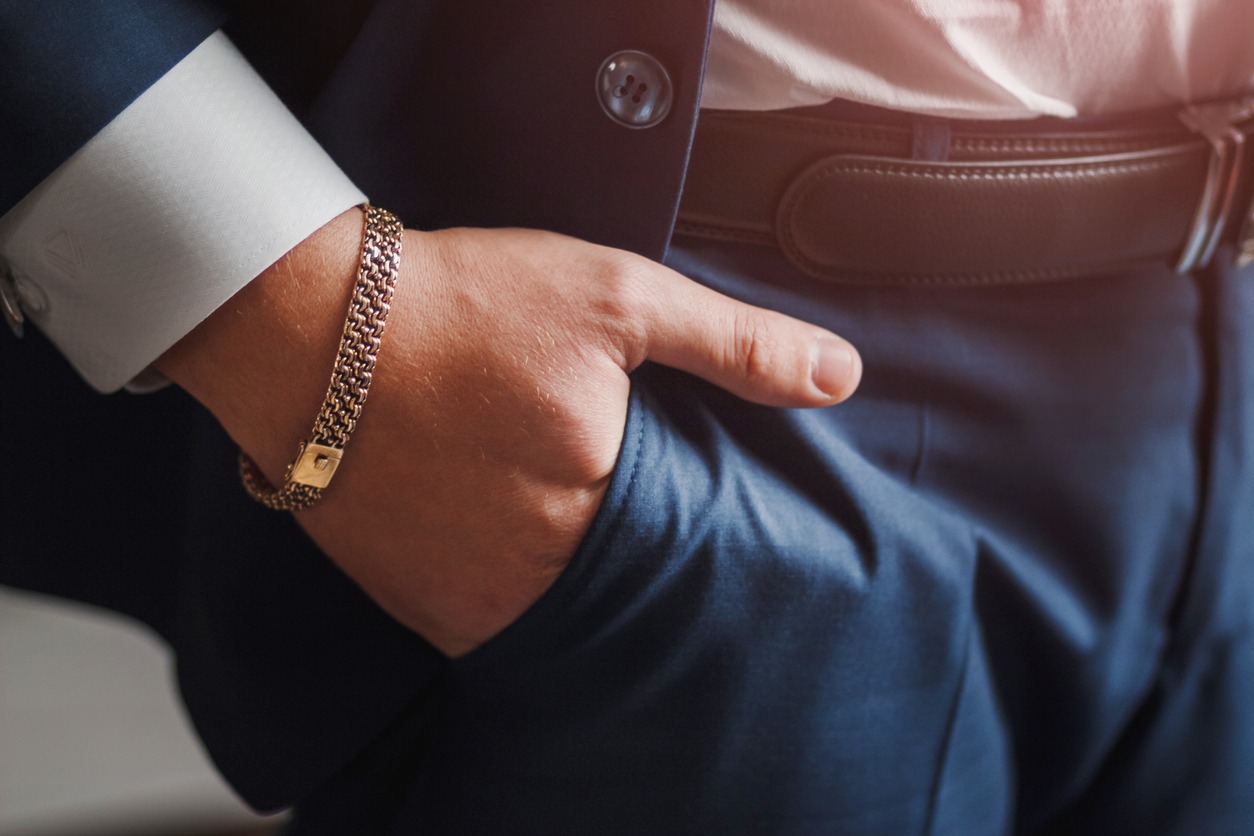  body detail of a business man. Closeup hand with jewelry chain in pocket