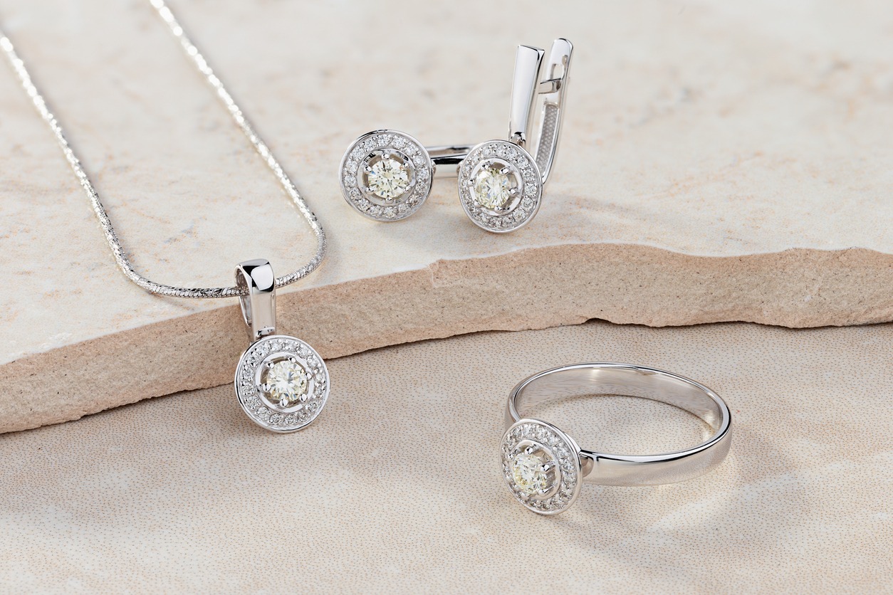 Elegant jewelry set of white gold ring, necklace and earrings with diamonds. Silver jewellery set with gemstones