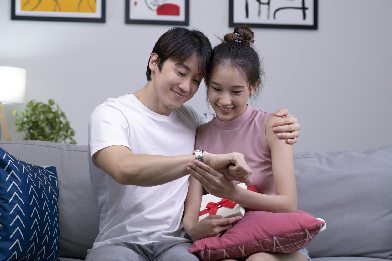 Young couple feeling happy while giving and receiving gifts from partner