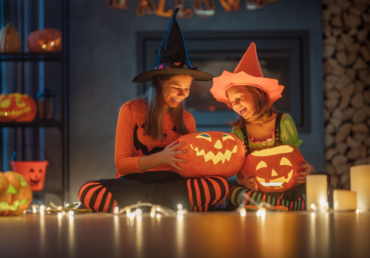 Friends in costumes holding pumpkin balls 
