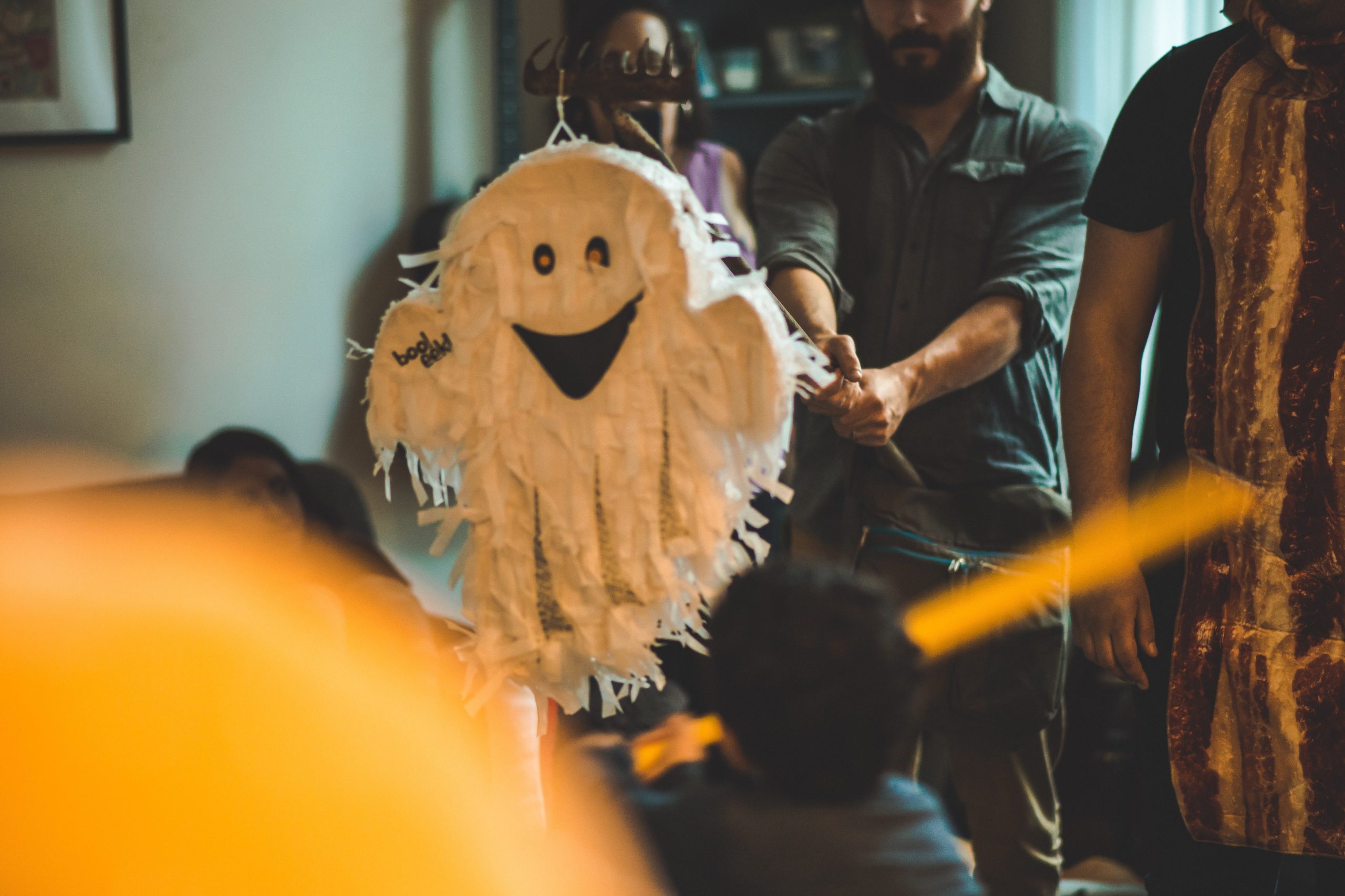 Group of friends gathering around a white ghost pinata