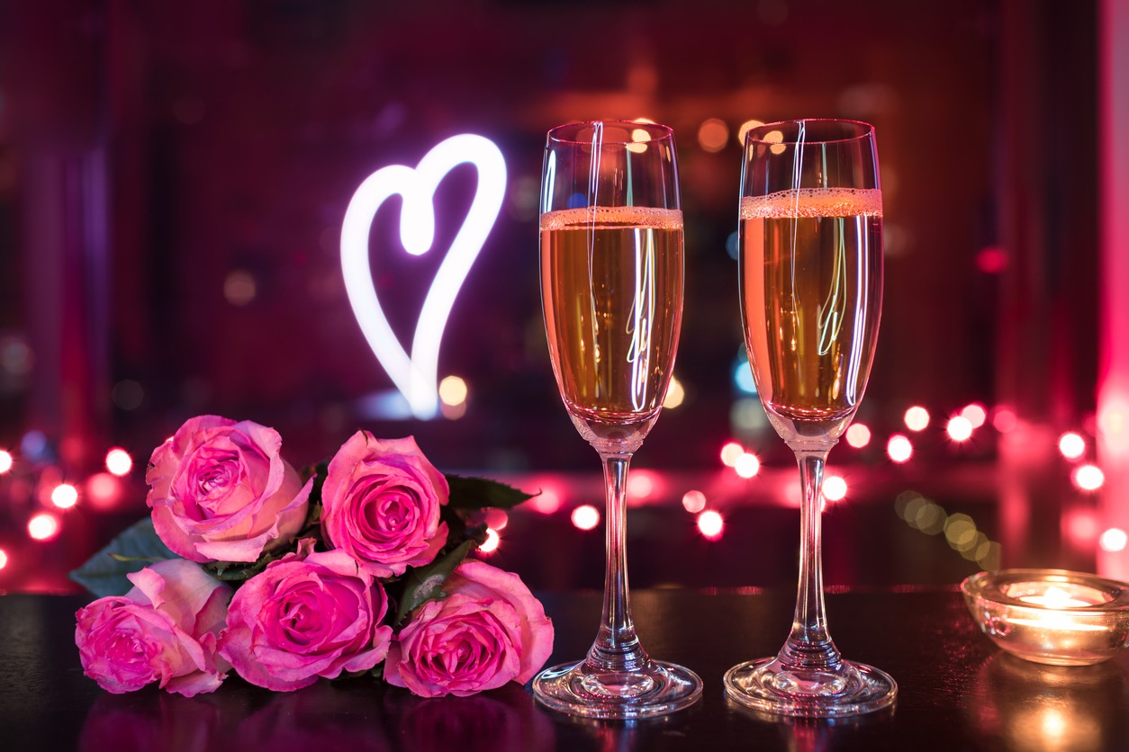 champagne drinks, roses, and neon heart light