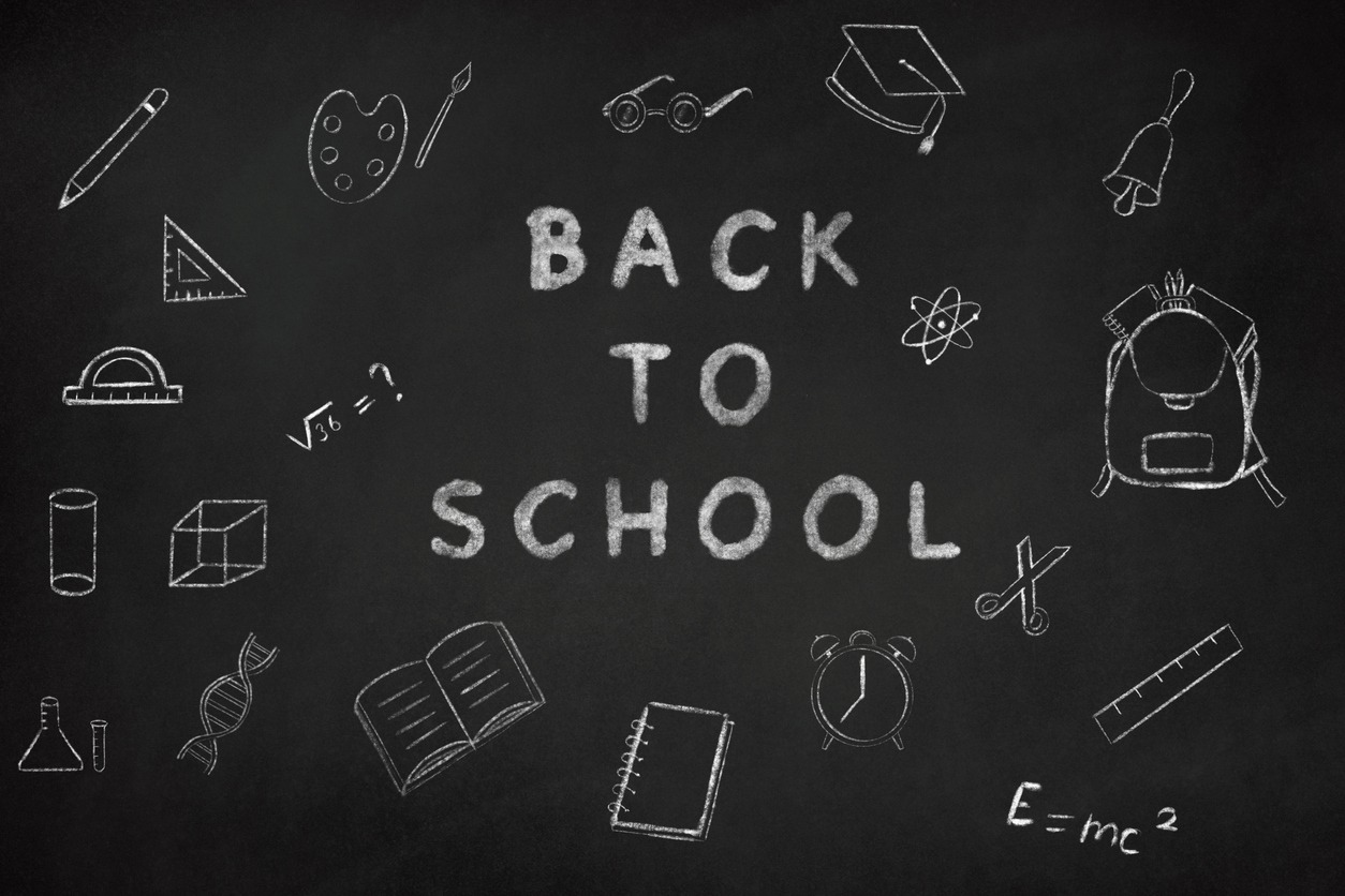 school supplies on a chalk board surrounding a “Back to School” lettering