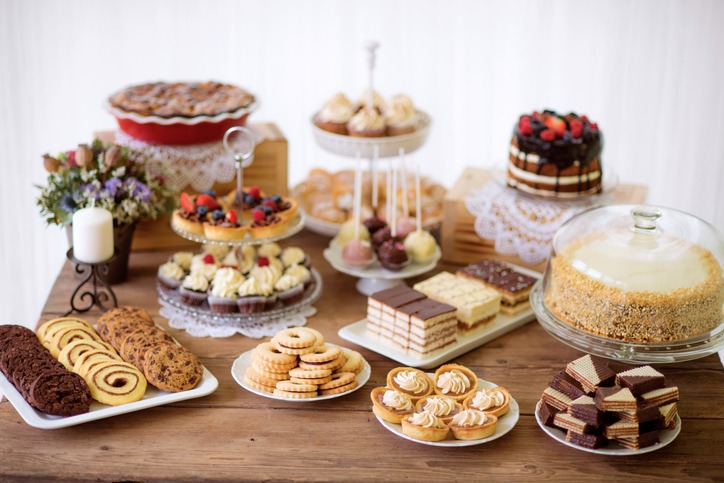 A dessert table with cookies, tarts, cakes, cupcakes and cake pops
