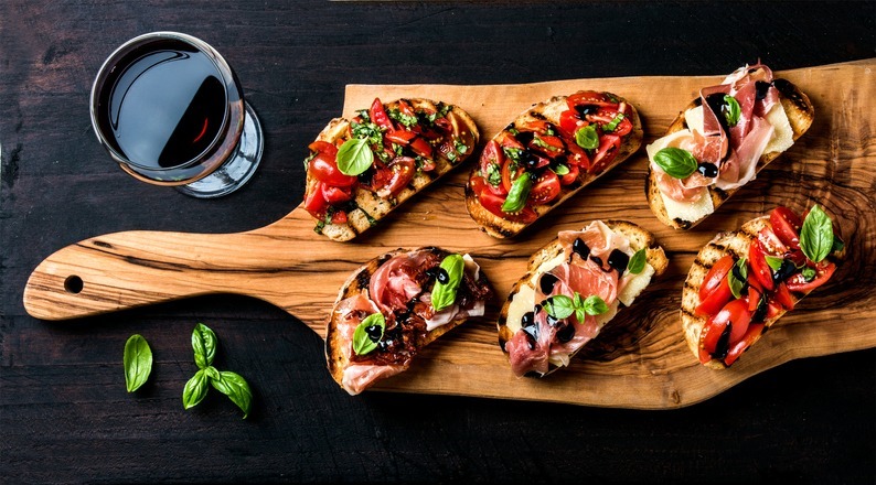 a set of bruschetta and a glass of red wine