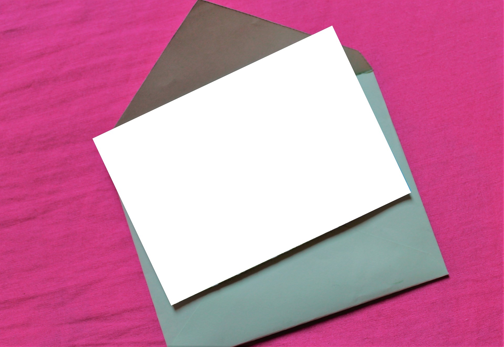 a blank invitation card against a pink background