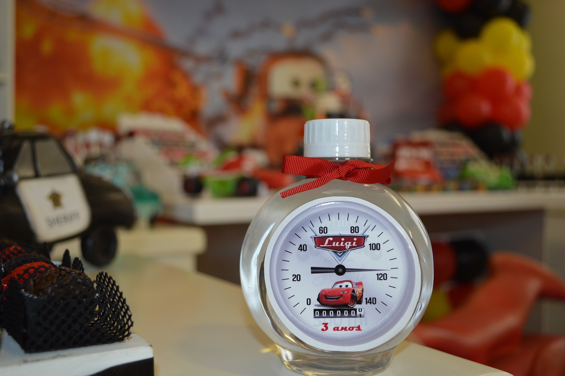 a cars-themed bottle with cars-themed decor at the background