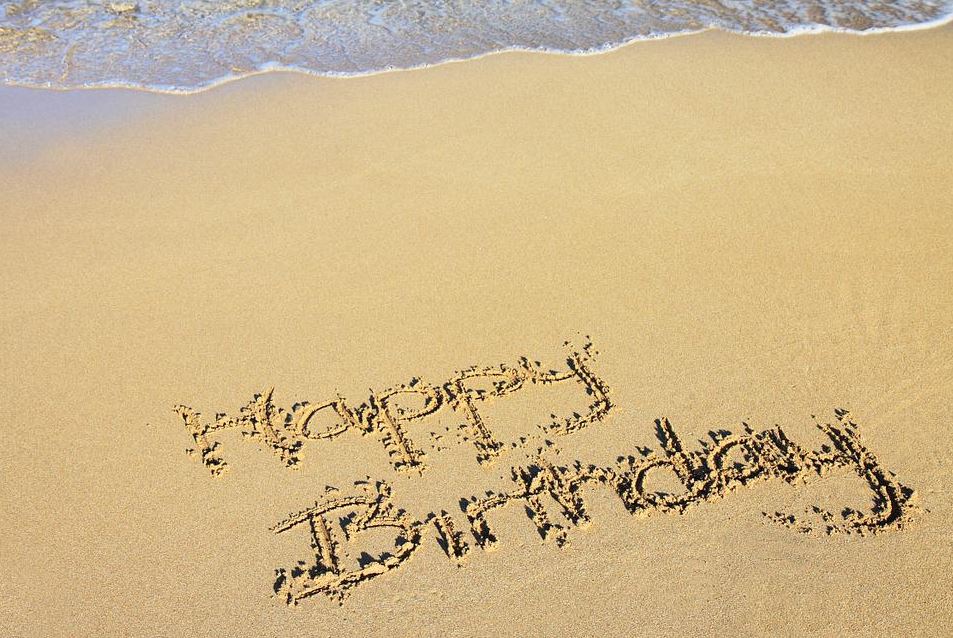 “Happy Birthday” written on the sand