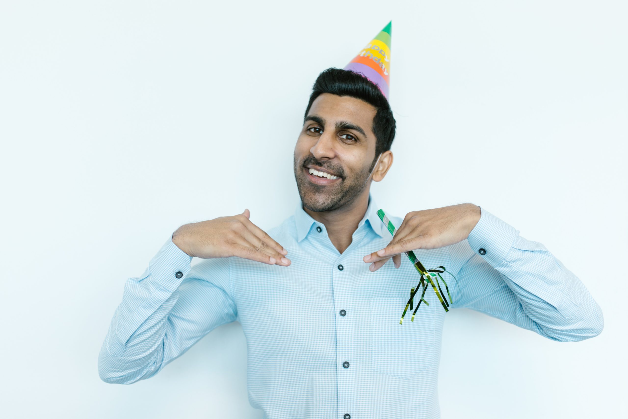 a man wearing a party hat and holding a birthday decor