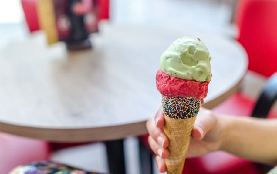 a person’s hand holding an ice cream cone