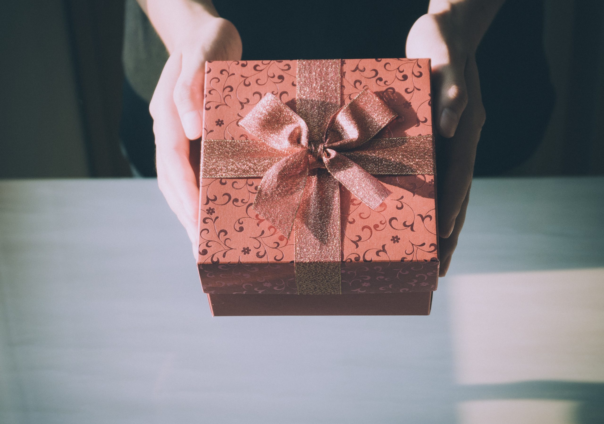 a person’s hands holding a gift