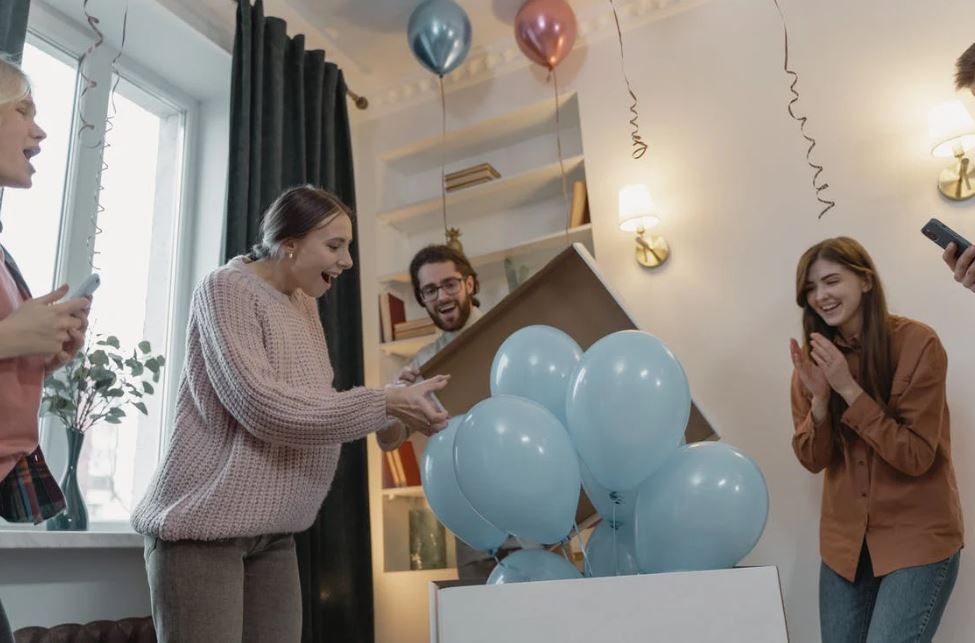 woman looking at blue balloons at a gender reveal party