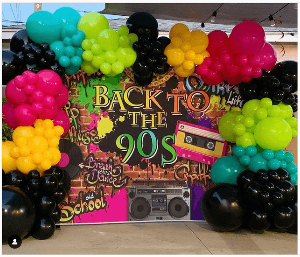 90s party decor with flashy retro backdrop and balloons