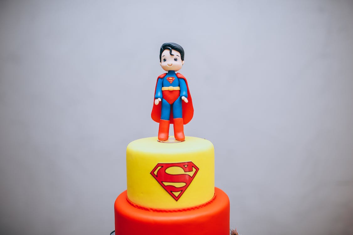a two-tier Superman themed cake with a Superman topper