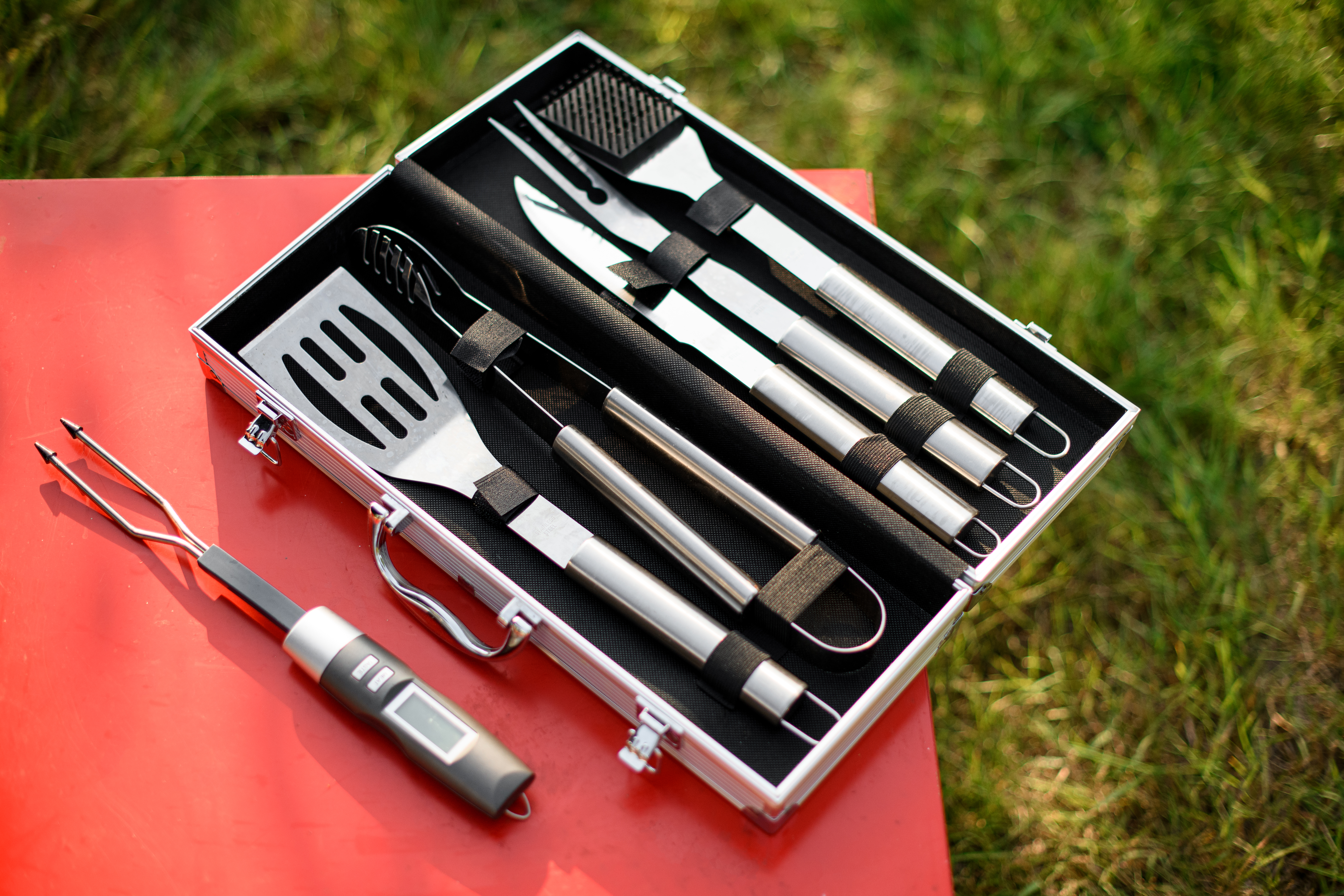 Top view on set of BBQ tools. Barbecue steel instruments kit - tongs, spatula, fork. Close-up