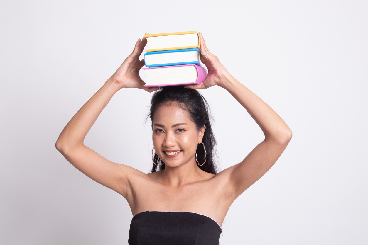 Asian woman playing book balancing